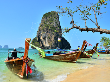 Wooden longtail boats moored on white sand at Railay-style beach with limestone karst and turquoise water