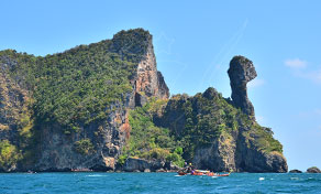 Limestone karst island with chicken-head shaped rock pillar and a longtail boat on turquoise sea, Krabi, Thailand