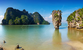 Limestone karst islands and Ko Tapu rock rising from turquoise water off a sandy beach in Phang Nga Bay, Thailand