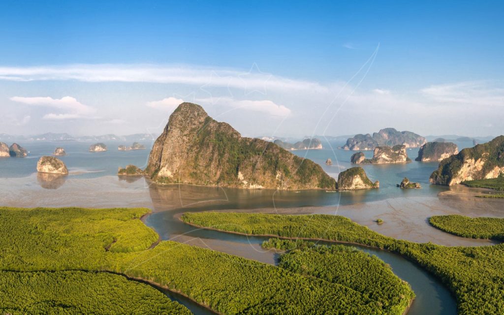 Aerial view of Phang Nga Bay limestone karst islands rising above winding tidal channels and green mangrove forest