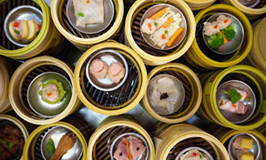 Overhead view of stacked bamboo steamer baskets filled with assorted dim sum dumplings and buns