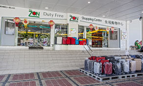 ZON Duty Free shopping centre storefront with suitcases stacked on pallets on tiled pavement outside