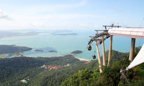 Cable car gondola and hilltop viewing platform above forested slopes overlooking turquoise sea and tropical islands
