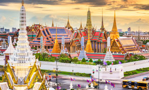 Golden spires and ornate rooftops of the Grand Palace and Wat Phra Kaew in Bangkok at sunset