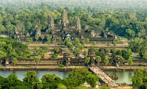 Aerial view of Angkor Wat temple complex with stone towers, moat and causeway surrounded by dense jungle