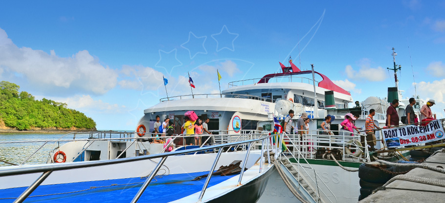 Ferry boats docked at pier with passengers boarding, sign reads 'Boat to Koh Phi Phi'