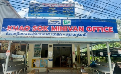 Khao Sok Minivan Office storefront with blue signage and power lines in Thailand