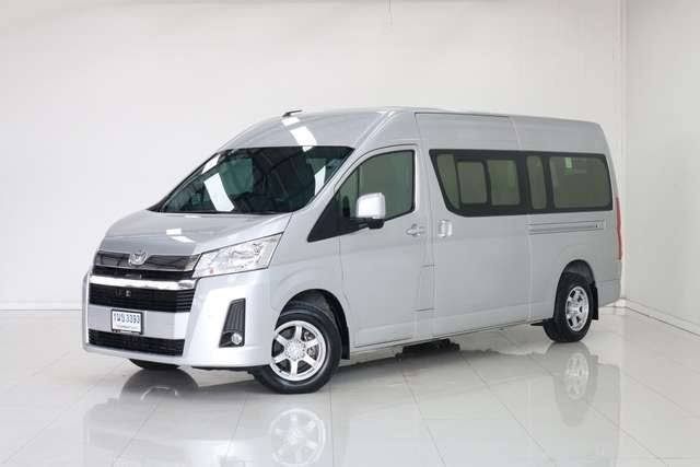 Silberner Toyota Hiace Hochdach-Kleinbus mit thailändischem Kennzeichen in weißem Studio-Showroom