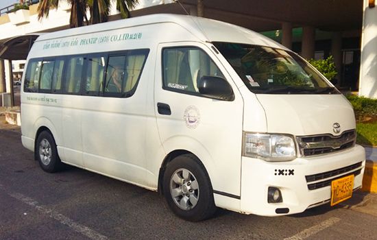 White Toyota Hiace minivan with Phantip Travel lettering parked at a covered transport terminal