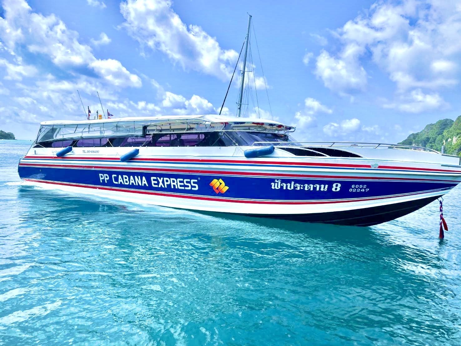 Blau-weißes Speedboot „PP Cabana Express“ auf klarem türkisem Wasser nahe Kalksteininseln, Thailand